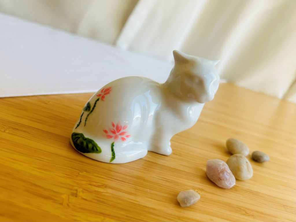porcelánová kočička s různými motivy z japonských zahrad